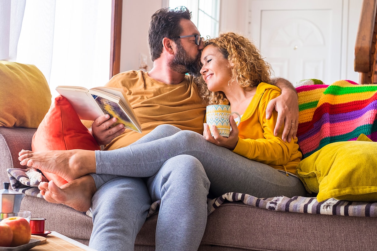 Mit Eltern-Tipps #GemeinsamStärker: Frischgebackene Eltern gönnen sich Auszeit auf der Couch.