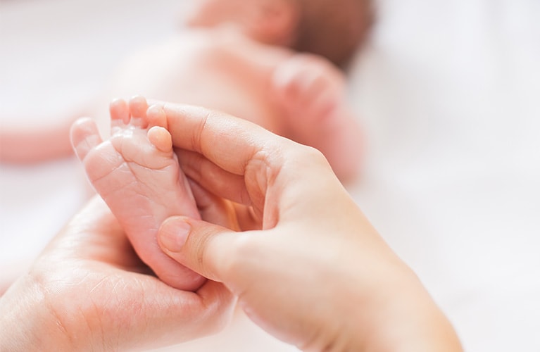 Mutter massiert den Fuß ihres Babys