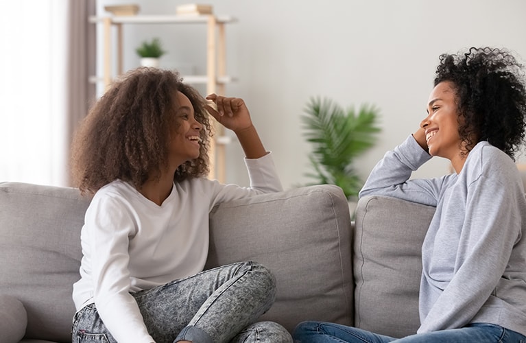 Zwei Frauen sitzen auf dem Sofa.