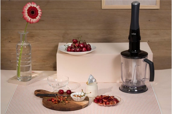 Sur une table est posé un mixeur et des fruits rouges 