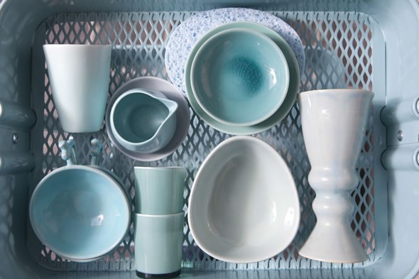 Panier en plastique contenant de la vaisselles : bols, verres, tasses de couleur bleu indigo