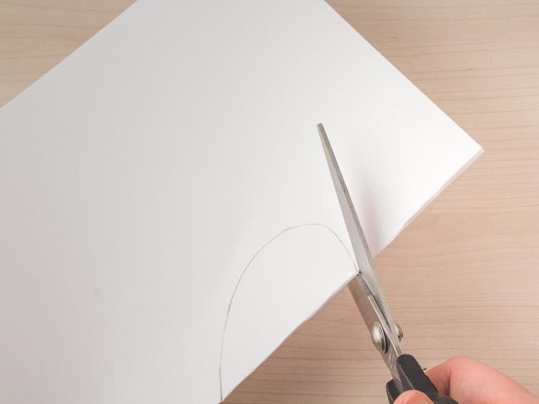 Knip met een schaar de vorm van het oor van het kopje uit op het kleefpapier.