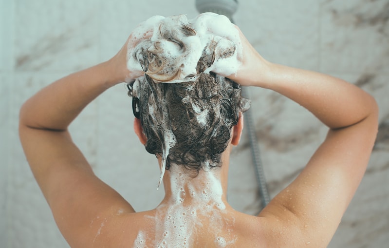 Haarpflege: Junge Frau beim Haarewaschen
