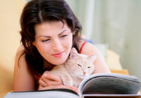 Frau mit Katze, die ein Buch liest