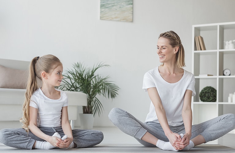 Frau mit Kind die Yoga machen