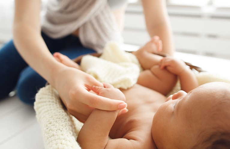 Junge Mutter mit ihrem Kind beim Baby-Yoga