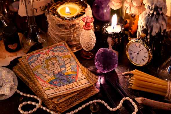 Tavolo con carte da tarocchi, candela e cimeli vari